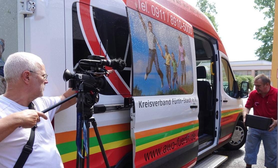 Kameramann vor AWO Bus mit Mitarbeiter (Dreharbeiten für Imagefilm)